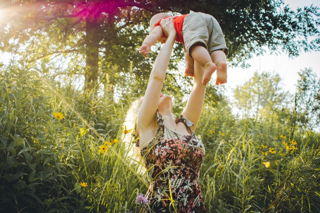 Mutter hält Baby in der Natur
